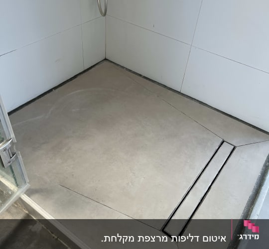 ריצוף רצפת מקלחון עם שיפועים ותעלת ניקוז ליניארית וחיפוי קירות